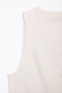 Detailed close-up showing the premium linen texture and V-neck stitching of the white vest