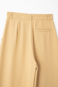 Détail du pantalon kaki à taille haute avec passants et poche arrière passepoilée