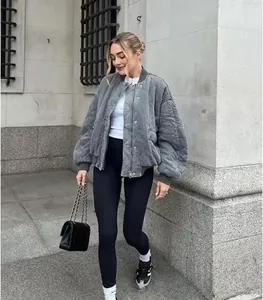 Close-up of diamond-quilted grey bomber jacket with ribbed cuffs and snap buttons