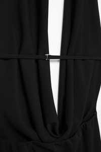 Close-up of halter neck dress detail featuring a silver metal buckle and pleated fabric