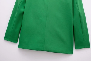 Close-up of bright green blazer back hem and cuffs with detailed woven fabric texture
