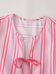 Detail of V-neckline with pink tie-up bow on a striped summer shirt for women