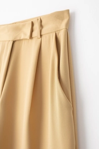 Détail des plis à la taille et des poches latérales sur ce pantalon large kaki