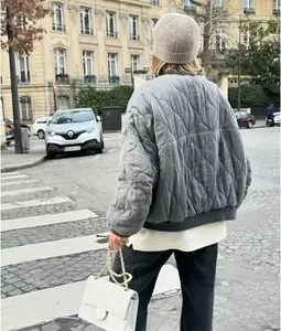 Rear view of a grey quilted bomber jacket with classic onion stitching in city setting