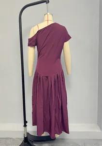 Détail d'une robe asymétrique violet foncé avec plis élégants et ourlet sophistiqué
