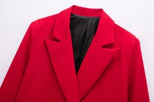 Detail view of red blazer notched lapel with neat stitching and black smooth lining