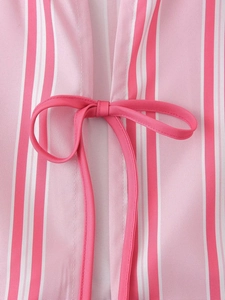 Detail of pink and white vertical stripes fabric with a neat decorative bow tie on summer shirt