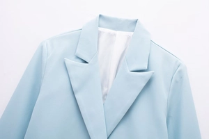 Detail of light blue blazer lapel with fine twill texture and white inner lining