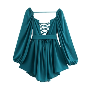 Detail of the deep V-neckline with criss-cross lace-up ties on a navy chiffon dress
