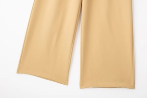 Gros plan détaillé du pantalon large kaki montrant les coutures de précision et le tissu