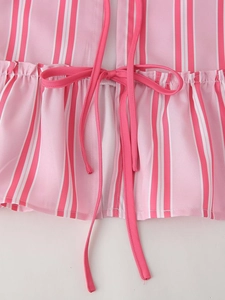 Detailed view of pink and white striped shirt with waist tie bow and pleated trim