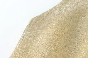 Detailaufnahme von goldenem Metallgewebe mit eleganter Faltenstruktur und Satin-Glanz