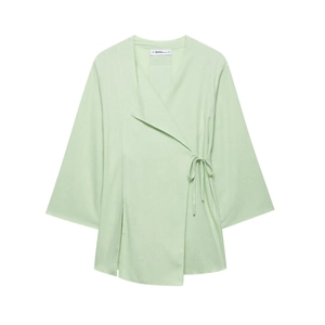 Detail of mint green linen wrap top featuring V-neckline and side drawstring closure