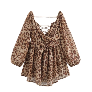 Detail view of leopard print dress featuring V-neck wrap design and waist tie bow