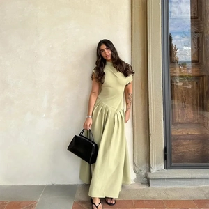 Détail de la taille plissée asymétrique et du tissu vert sauge de cette robe longue