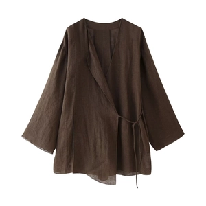 Detail of dark brown linen V-neck wrap top with side-tie and natural wrinkled texture