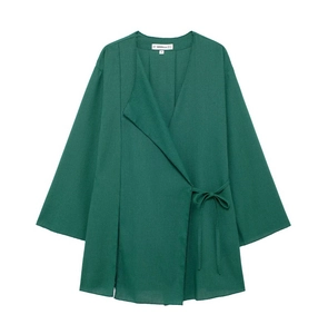 Detail of dark green linen wrap top with V-neck, side ties, and branded neck label
