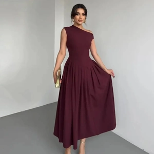 Détail de l'ourlet plissé bordeaux foncé et du drapé fluide de la robe à une épaule