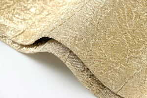 Makroaufnahme von champagnergoldenem Schimmerstoff mit detaillierter Metallwebstruktur
