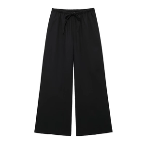 Detail of black linen trousers with elastic drawstring waistband and loose wide-leg cut