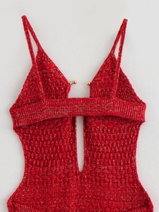 Detailed macro view of the red knit bodysuit featuring metallic yarn and gold bead accents