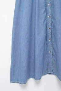 Detail view of the button-down front and twill fabric texture on blue denim midi dress
