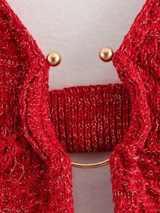 Detail of red knit dress with gold metallic beads showing intricate texture and fabric