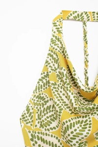 Detail eines gelben Neckholder-Kleids mit geflochtenen Trägern und Punktmuster