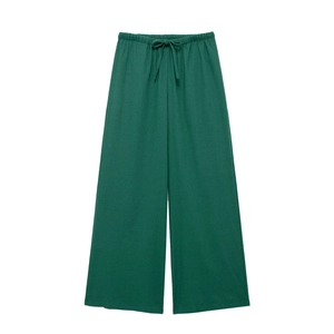 Detail of dark green wide-leg linen pants with high-waist elastic band and drawstring