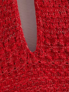 Detail of red knit dress featuring golden metallic yarns and hollow texture patterns