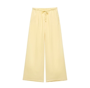 Detail of light yellow linen trousers with an elastic waistband and drawstring