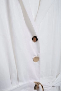 Vue détaillée d'une robe chemise en lin blanc avec boutons dorés et boucle de ceinture