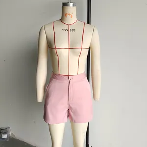 Detail view of pink high-waisted shorts featuring button closure and side pockets