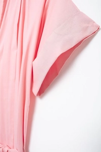 Close-up of pink short-sleeved shirt dress with pleated neckline and waist tie detail