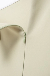 Détail de la fermeture éclair invisible sur le côté de la robe d'été vert clair texturée