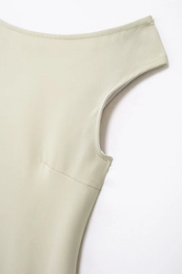 Détail de la couture de l'épaule et de la texture plissée de la robe mi-longue beige