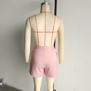 Detail of light pink high-waisted shorts with flat woven texture and tailored fit back