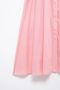 Detailed macro view of the light pink cotton-linen hemline with neat stitching
