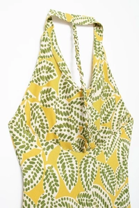 Detail des gelben Neckholder-Tops mit grünem Blattmuster und geflochtenen Bändern