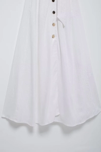 Détail d'une robe chemise blanche en coton et lin avec boutonnage avant et ceinture assortie