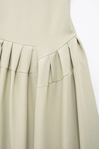 Détail de la taille plissée asymétrique sur cette élégante robe longue kaki clair