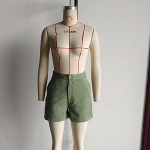 Detail of olive green high-waisted cotton shorts with button fly and belt loops