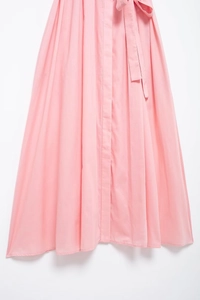 Detailed view of a pink summer shirt dress featuring a waist tie and pleated fabric texture