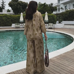 Dettaglio del completo jacquard morbido con camicia e pantaloni floreali a bordo piscina