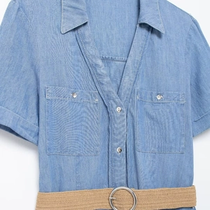 Light blue short sleeve denim midi dress with a V-neck, chest pockets and woven belt