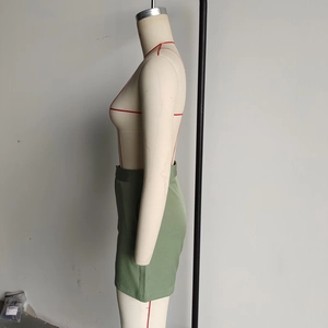 Detail view of army green high-waisted shorts with side pocket stitching on a mannequin