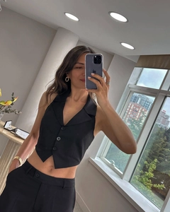 Detail of a chic black three-button cropped vest and matching high-waist suit trousers