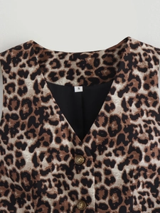 Dettaglio del gilet con stampa leopardata, scollo a V e bottoni color ambra