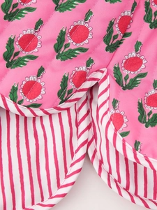 Detailed close-up of quilted floral fabric with red striped edging and inner lining
