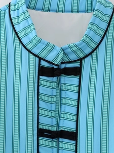 Close-up of Mandarin collar and black handcrafted frog buttons on light blue striped vest
